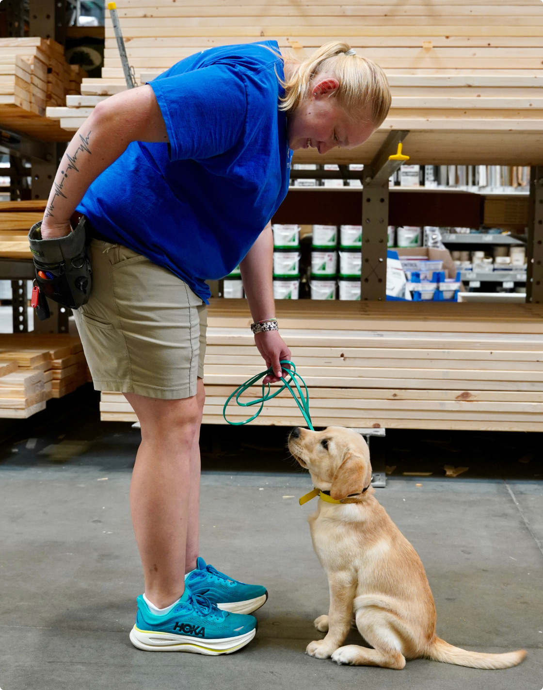 A Love in the Lead trainer working with a yellow Labrador puppy on a loose leash